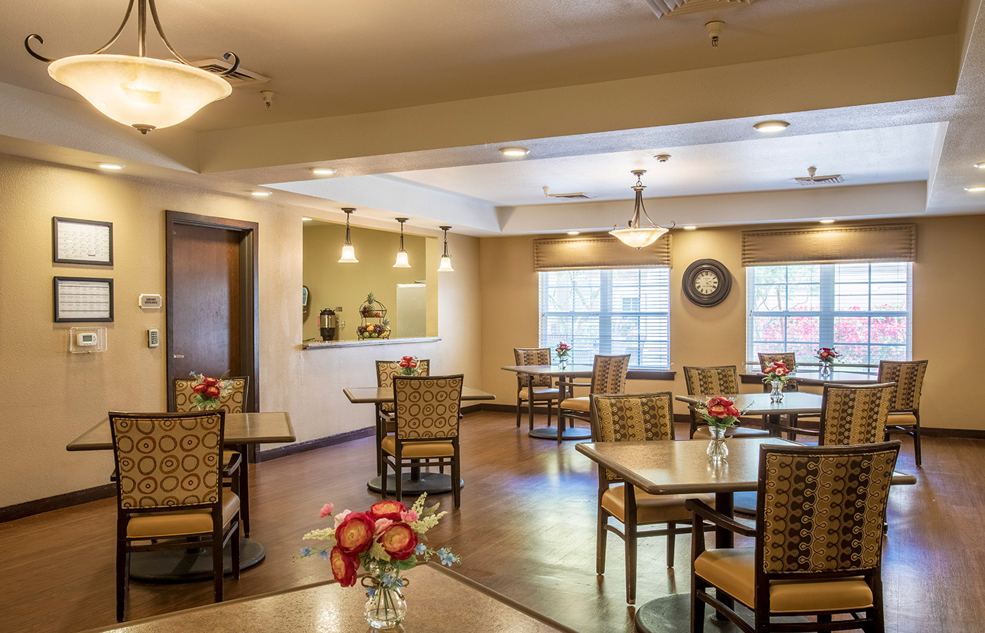 The dining room including dinner tables and large windows on the back wall.