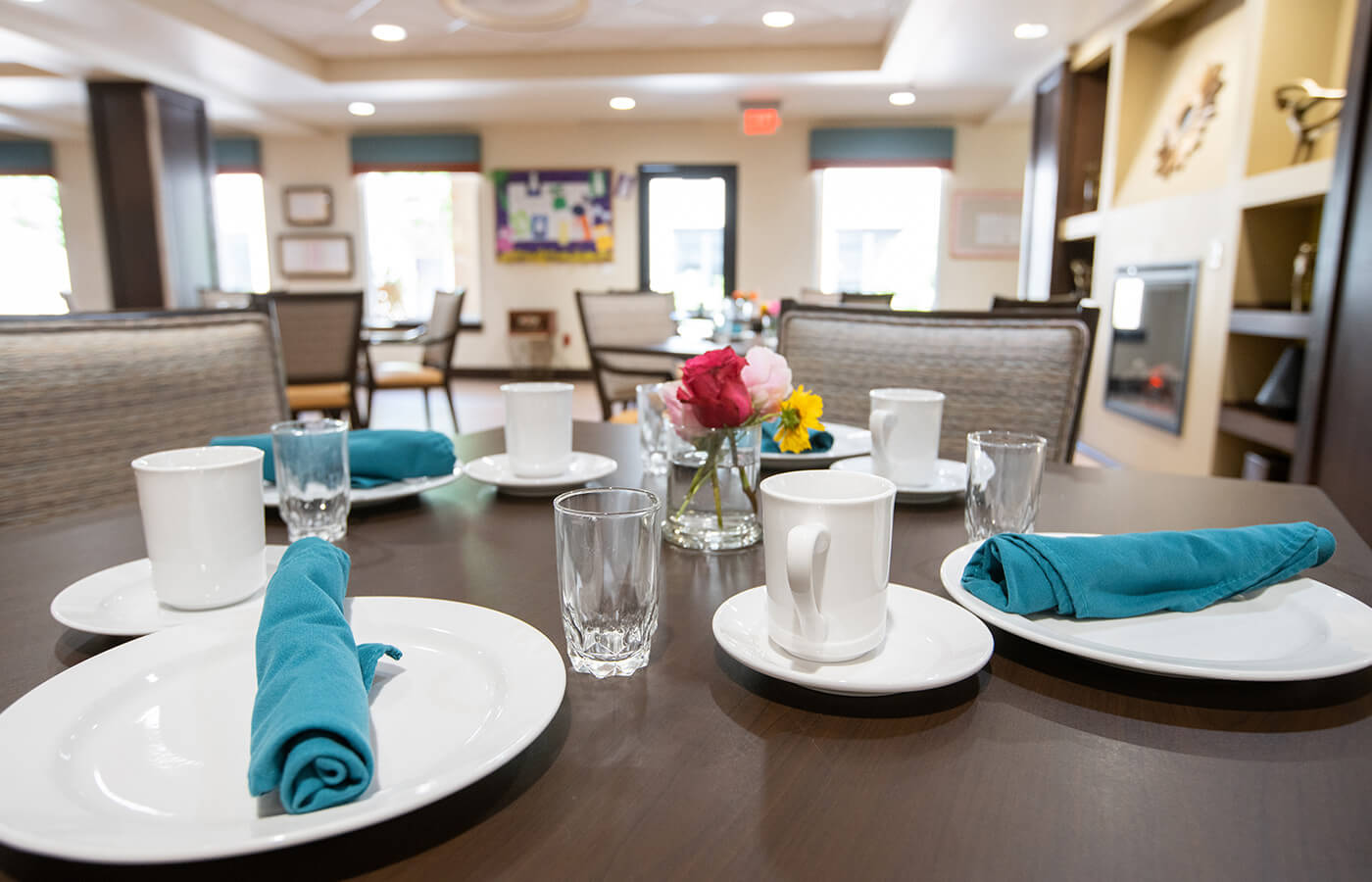 The Watermark at Cherry Hills dining room set table with plates, napkins, and glasses.