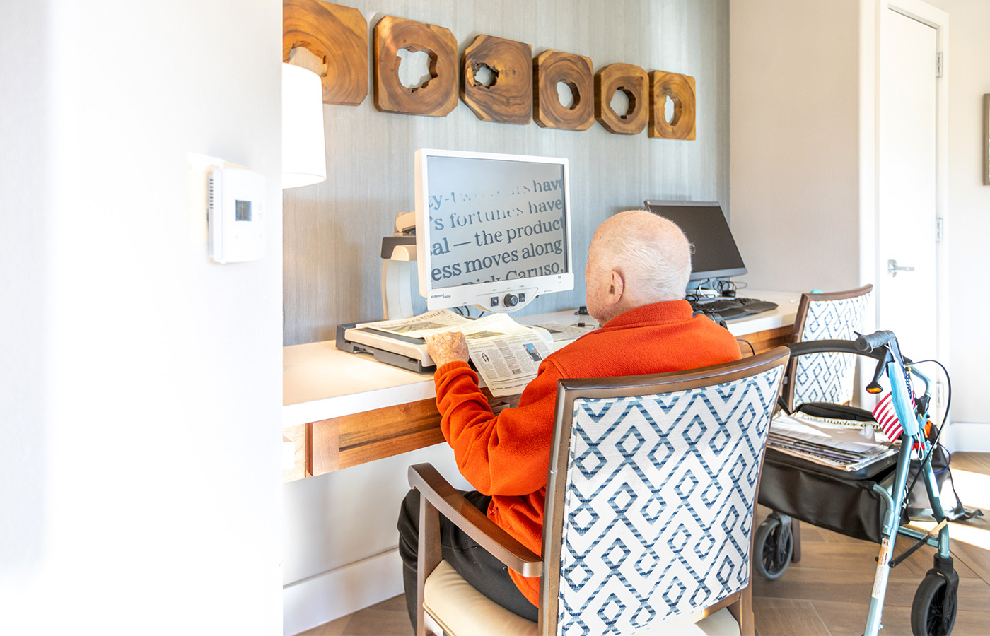 A resident is sitting and typing on a computer.