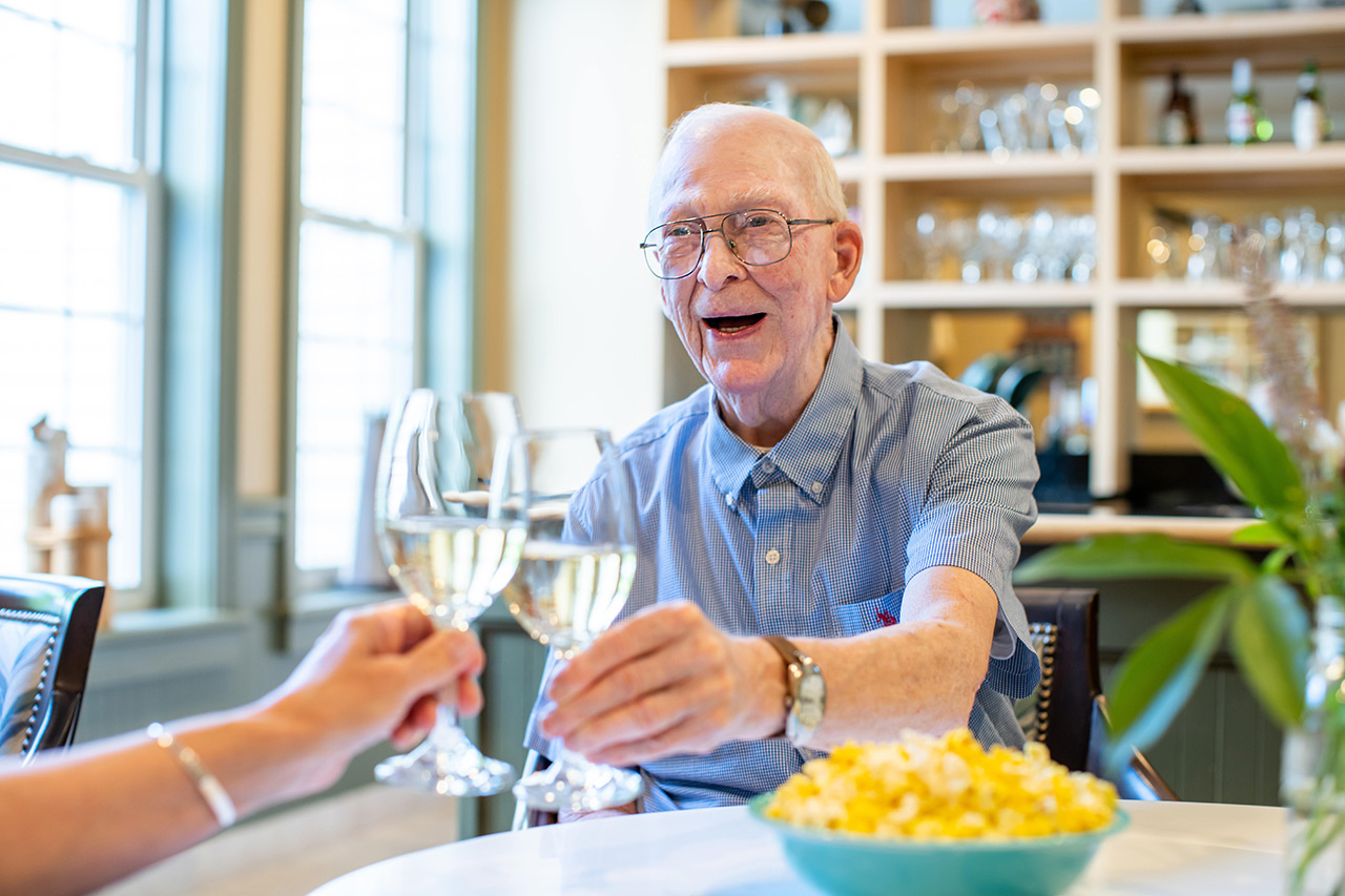 A resident is clinking their glass with another resident.