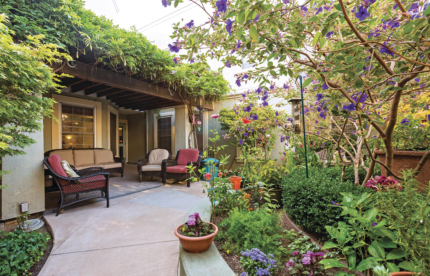 patio chairs in covered area within luscious garden