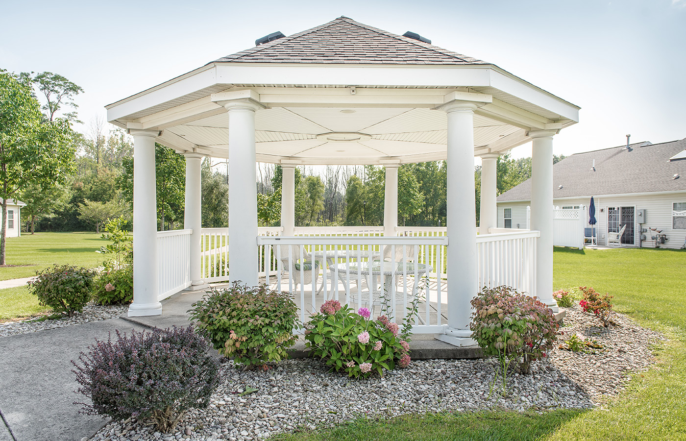 Gazebo surrounded by bushes.