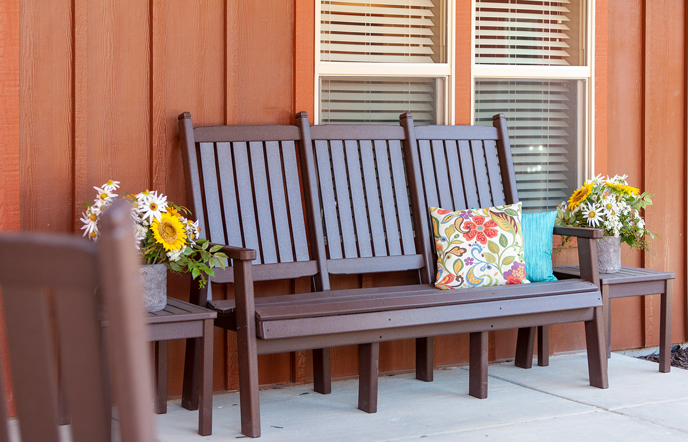 Brown bench with flowers.