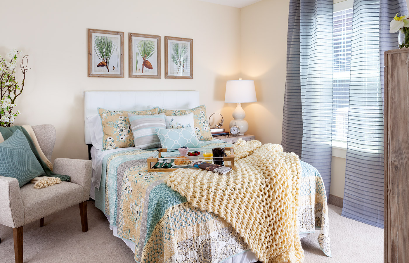 Furnished bedroom with bed, window, and dresser.