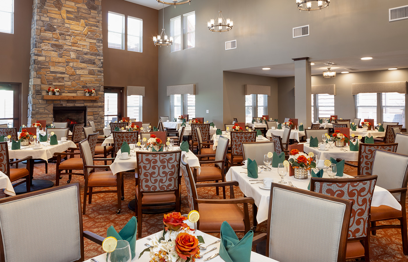 Dining room with seating area filled with tables, chairs and windows.