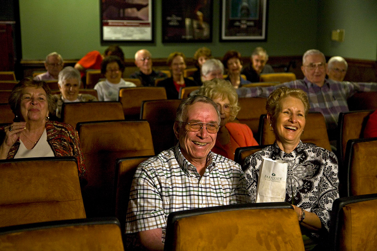 Residents watching a movie in the media room.