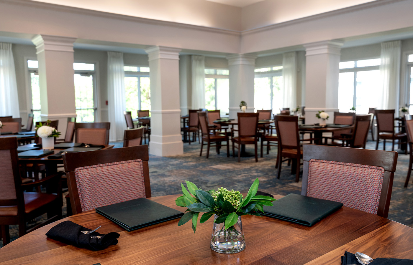 A dining room with tables and chairs.