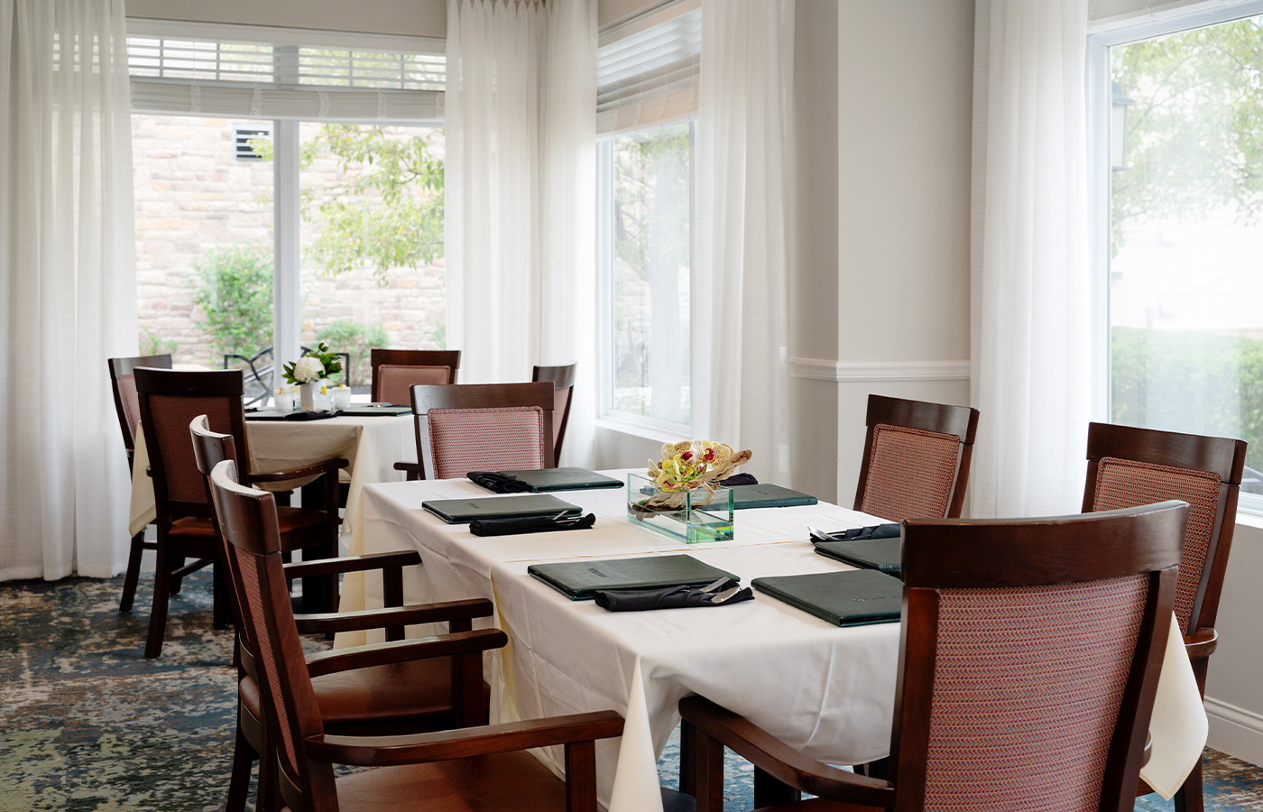 A dining room with tables and chairs.