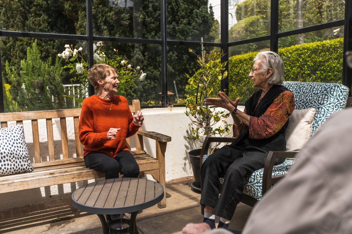 Two residents having a conversation outside.