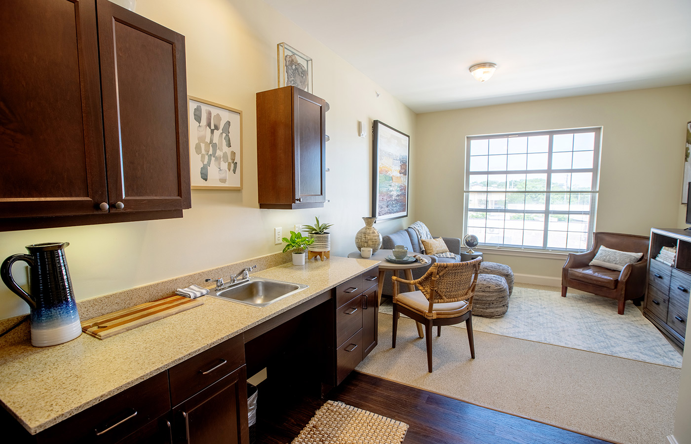 A furnished kitchen looking into the living room.