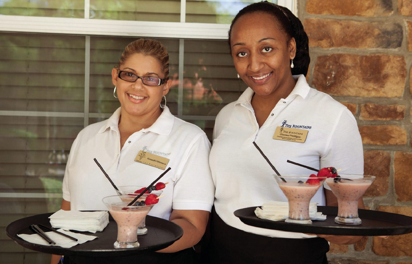 Associates holding trays of drinks.