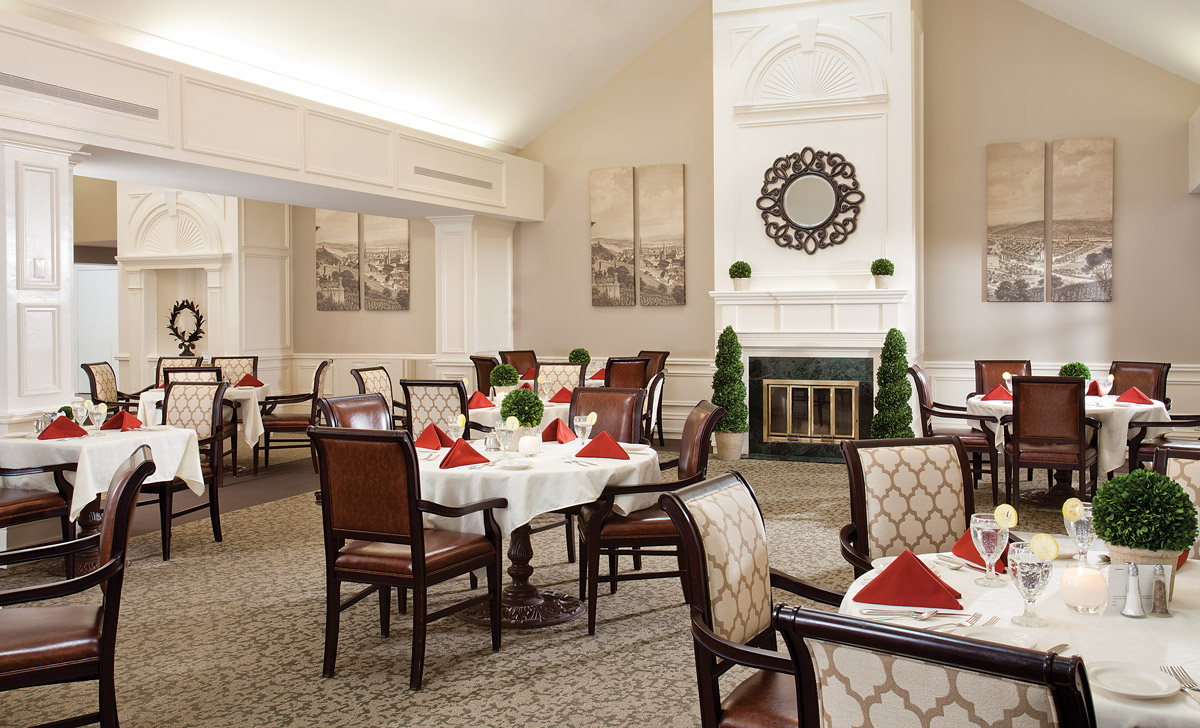 Dining room with seating area and set plates.