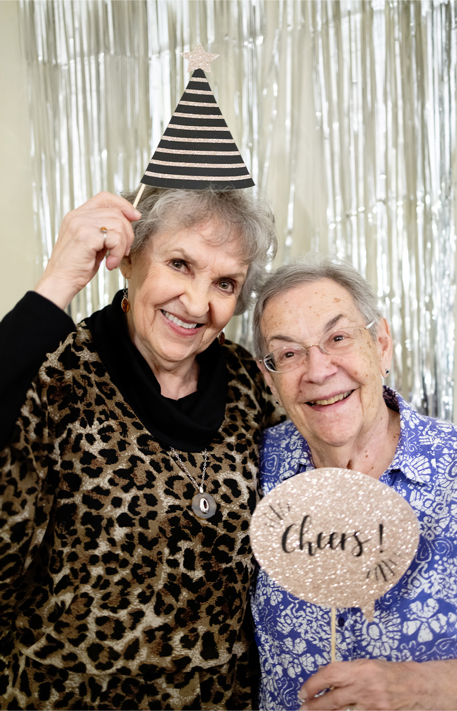 Two people with a party hat and sign.