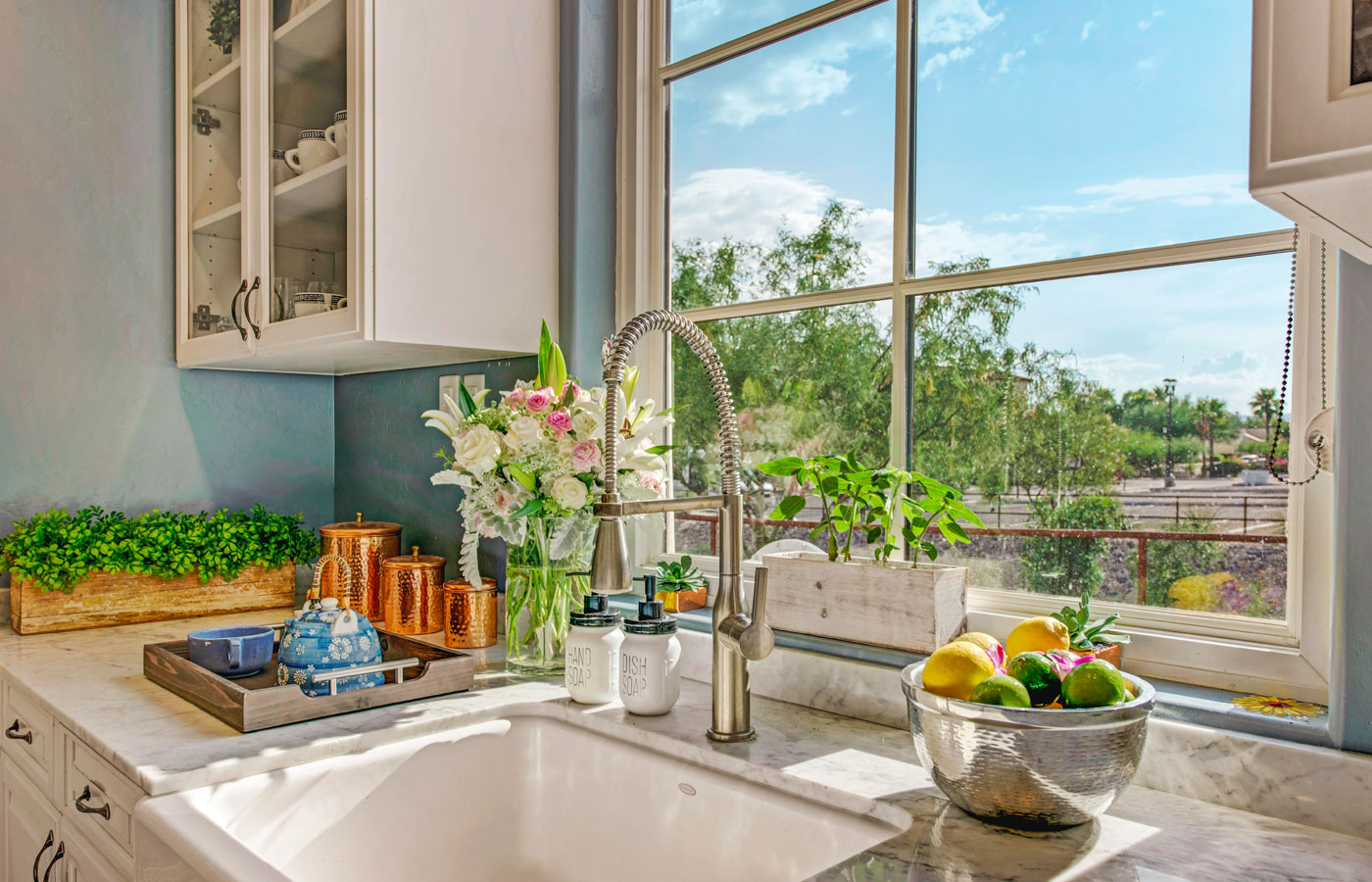 A farmhouse sink looking out to a bright blue sky.