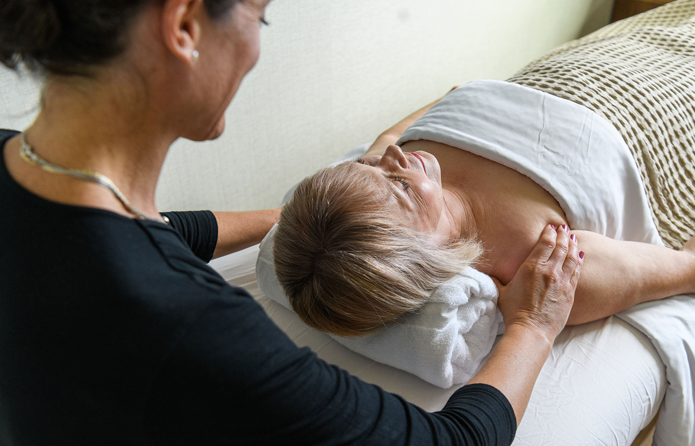 A resident gets massage by masseuse.
