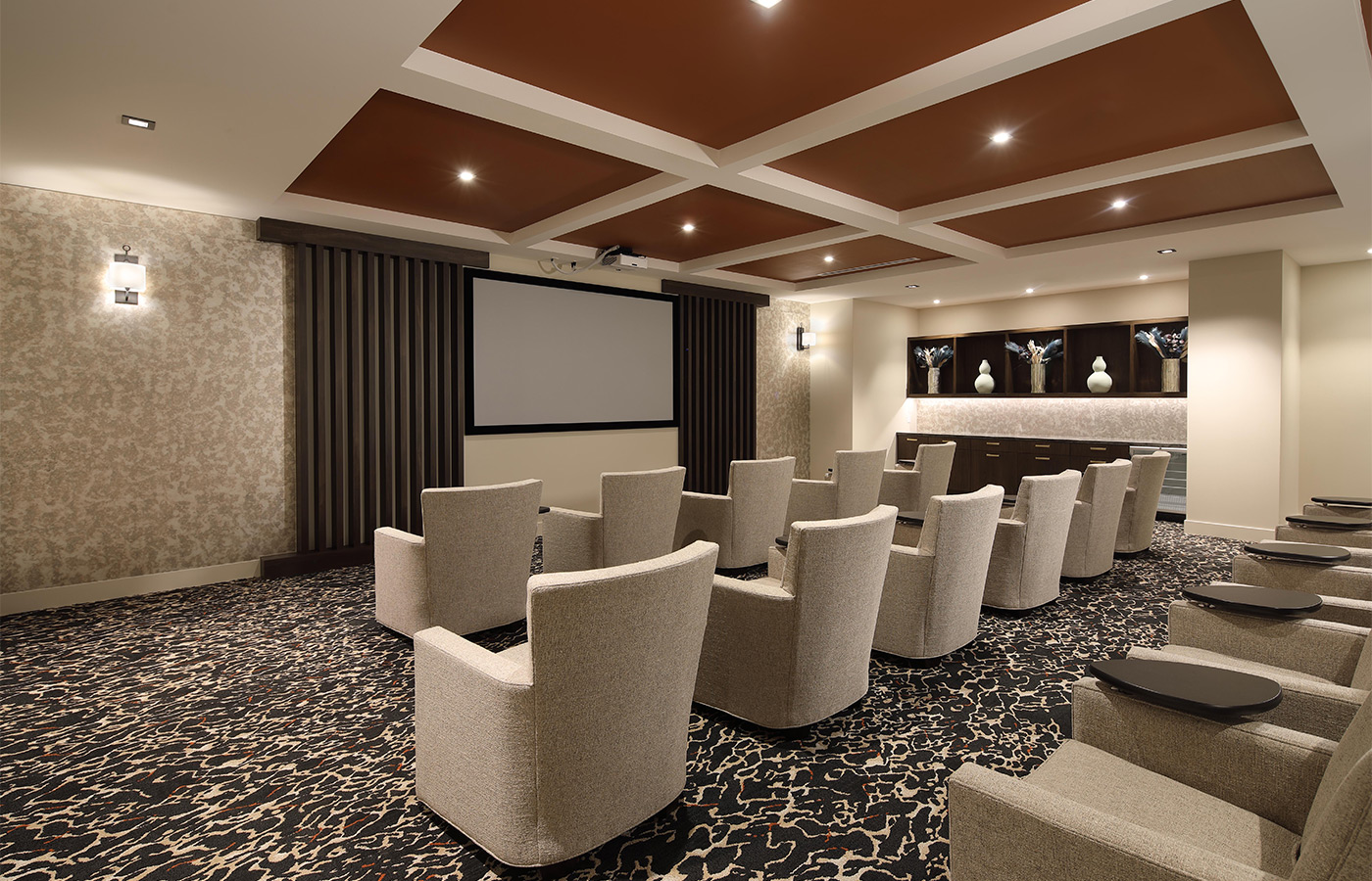 A theater with a screen and big chairs.