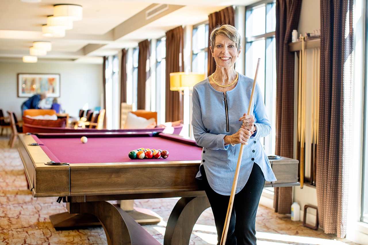 A resident is standing in front of pool table.