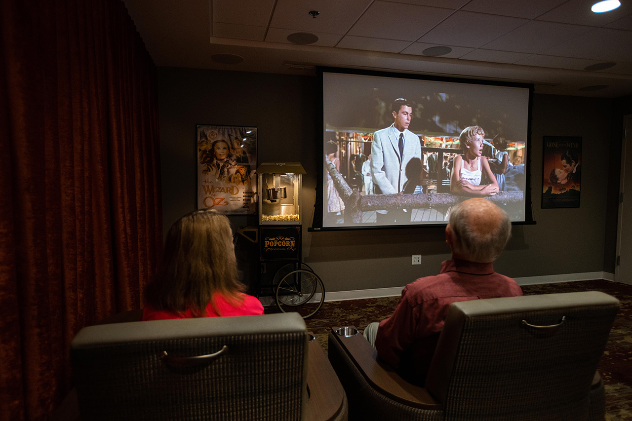 Two residents are in a theater watching a movie.