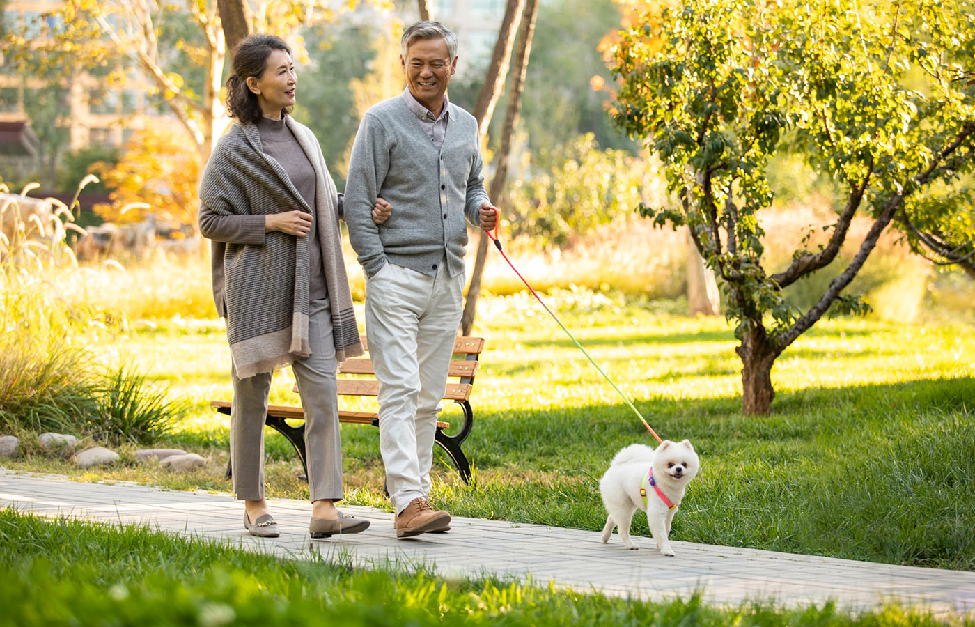 Two residents walking their dog outside.