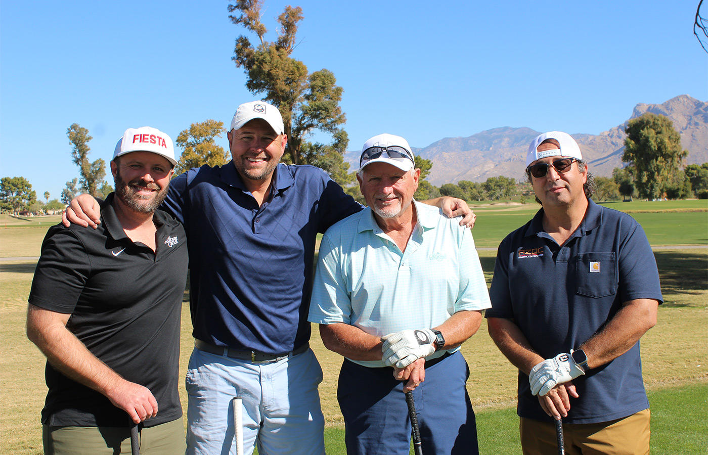 People standing on a golf course smiling.