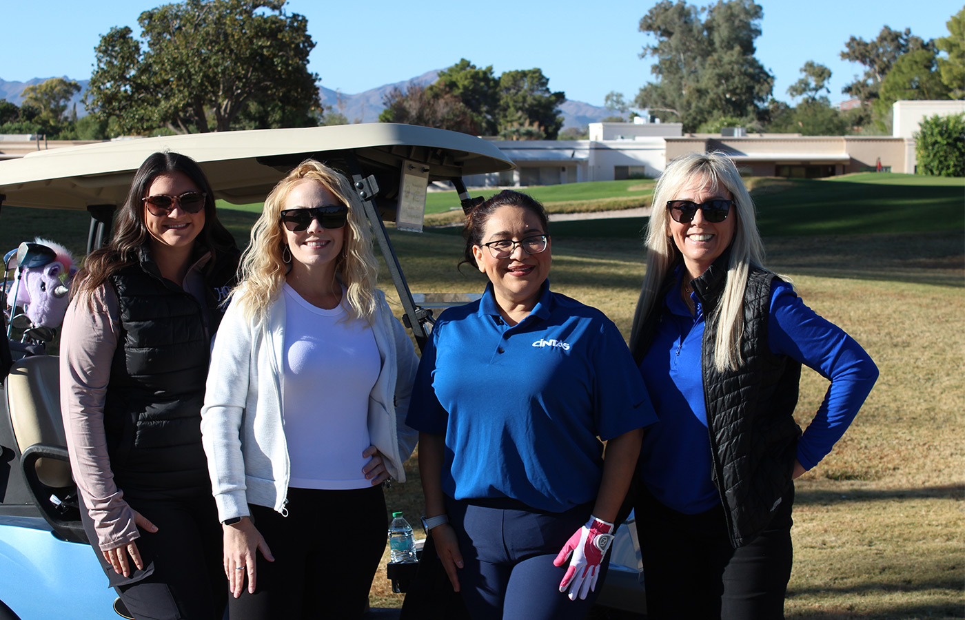 People standing on a golf course smiling.