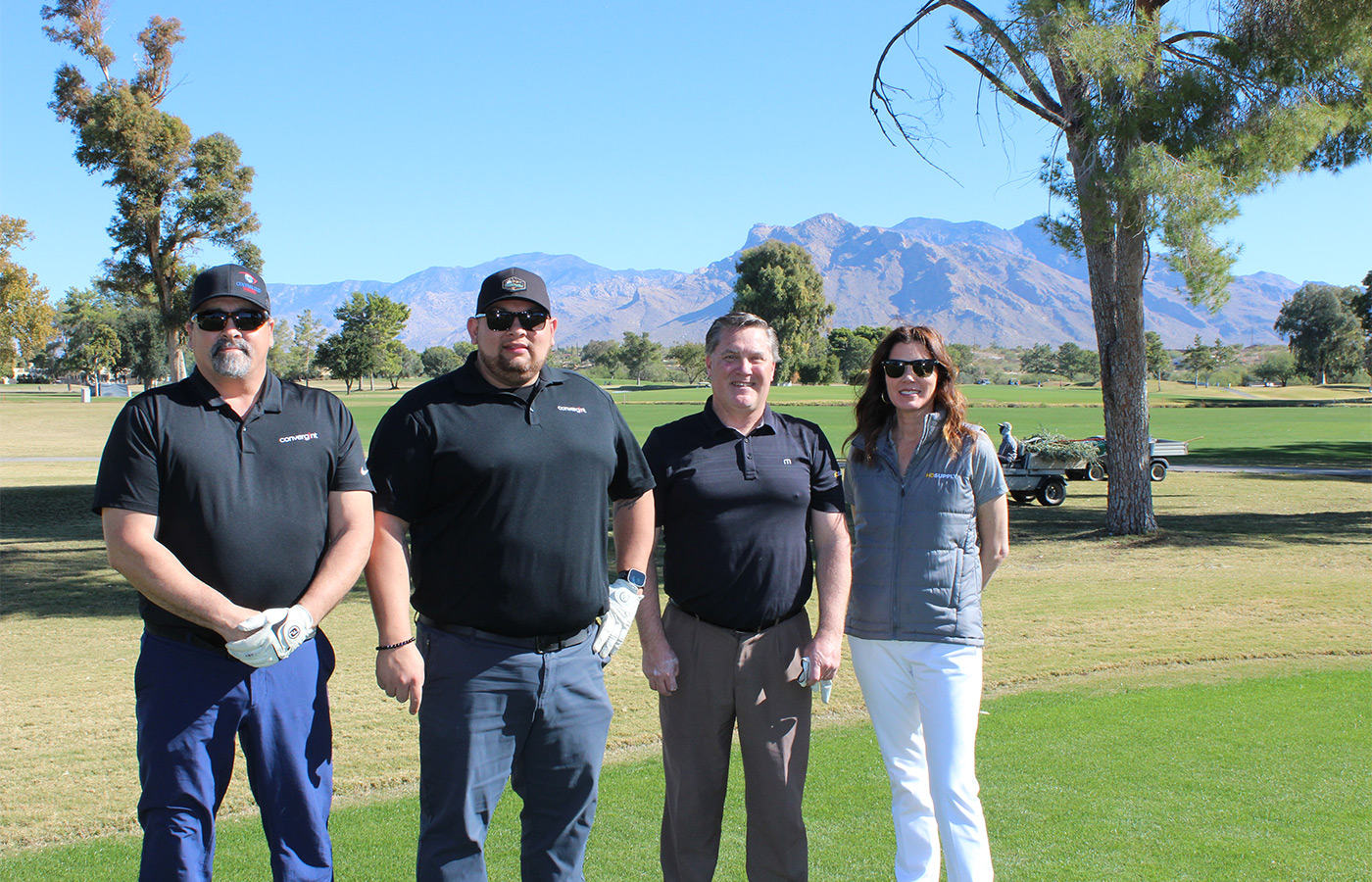 People standing on a golf course smiling.