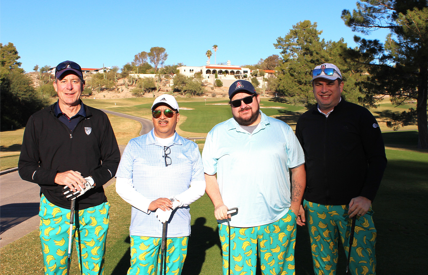 People standing on a golf course smiling.