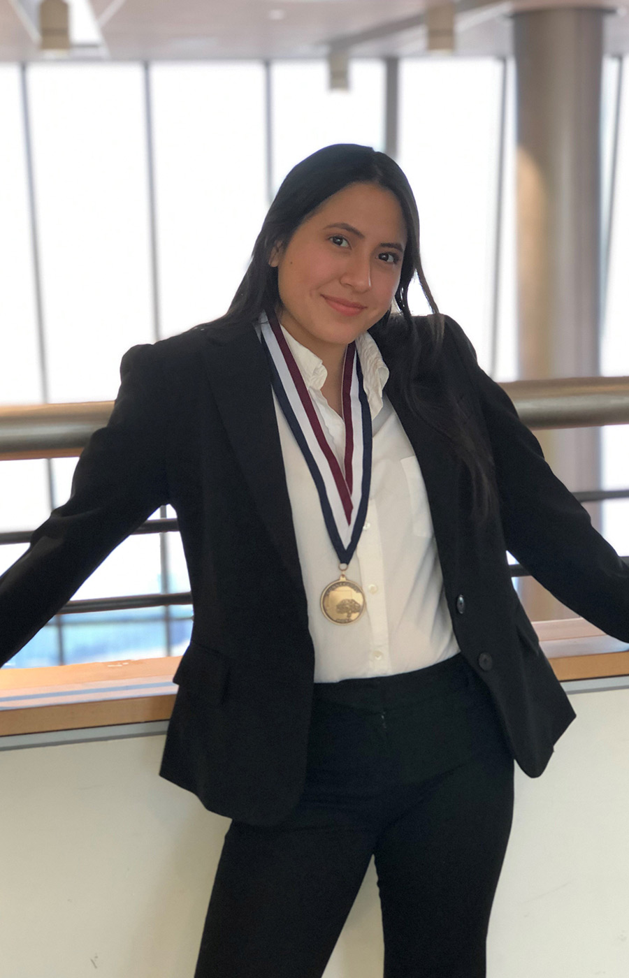 person wearing professional attire and a medal