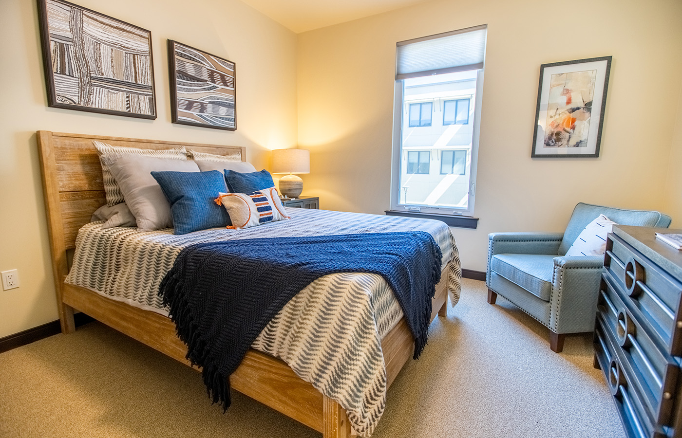 The Watermark at Cherry Hills apartment with two paintings above bed.