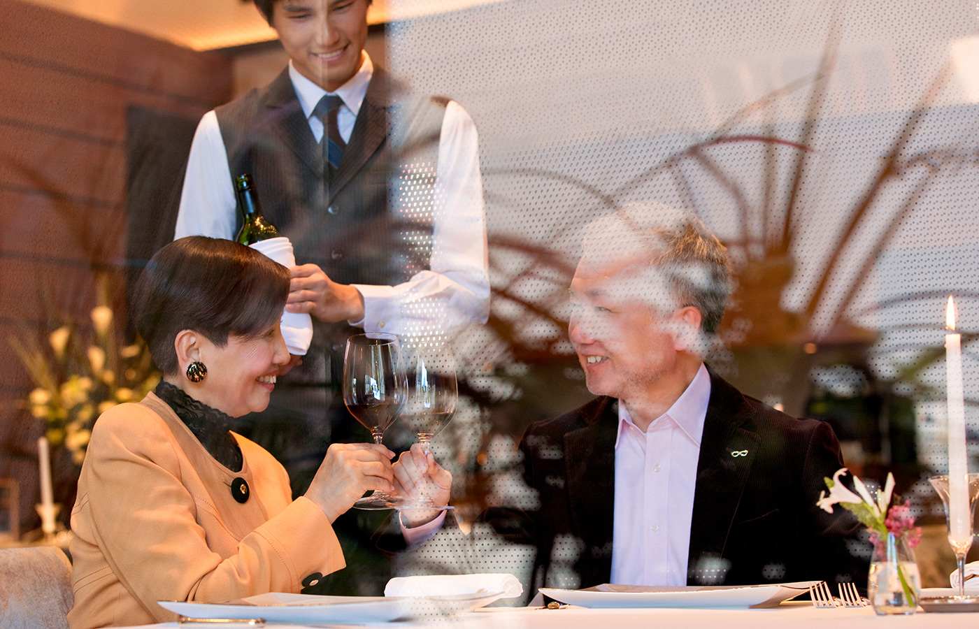 Two people drinking wine at dinner.