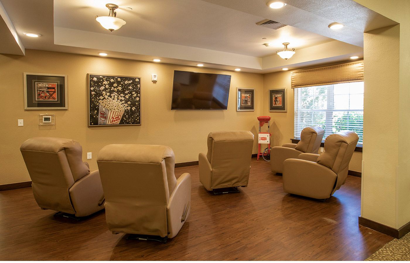 A large tv screen and armchairs in the Theater room.