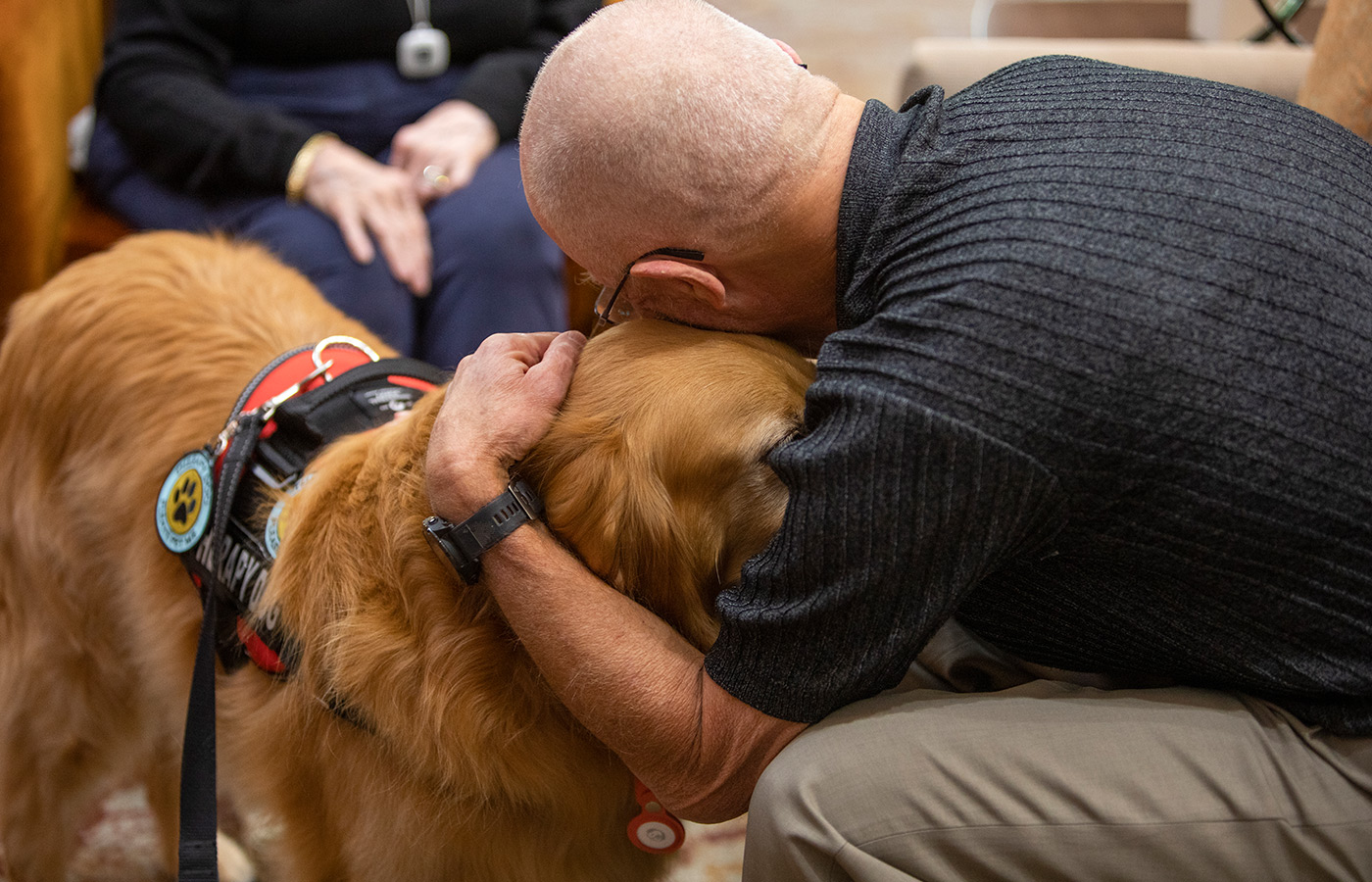 A resident is hugging a dog.