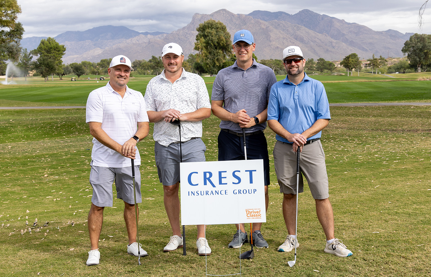 A group of people standing next to each other on the golf course.