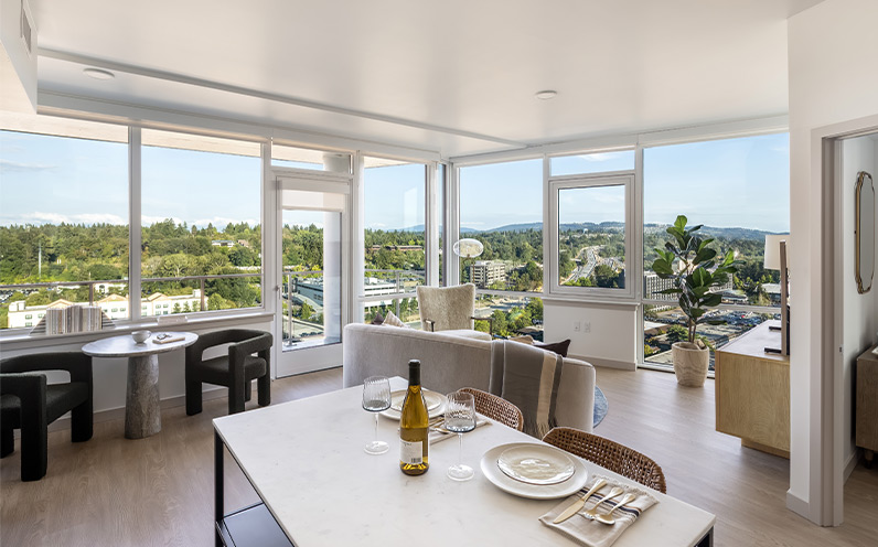 A fully furnished living room with floor to ceiling windows.