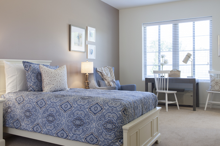 Furnished bedroom with bed by a window.