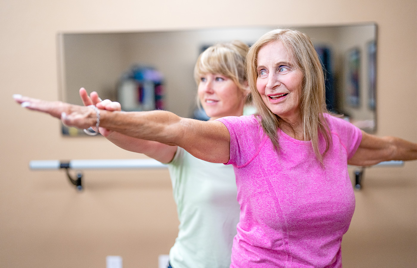 A person stretching with a trainer.