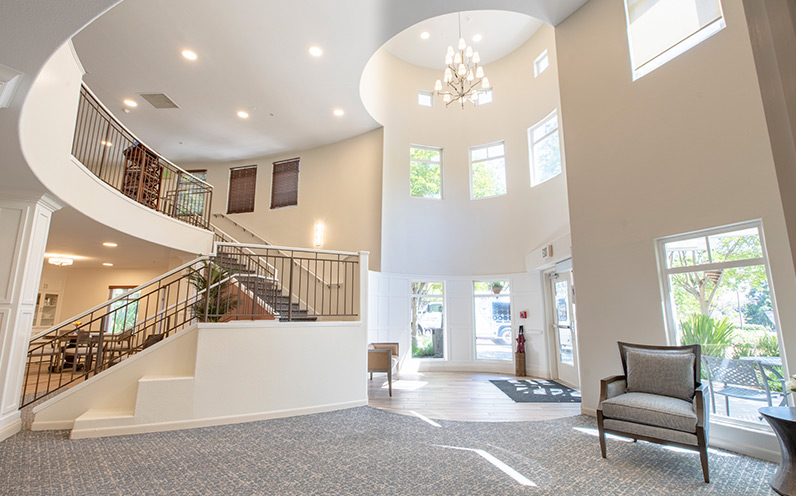 A lobby with lots of light and a curving staircase.