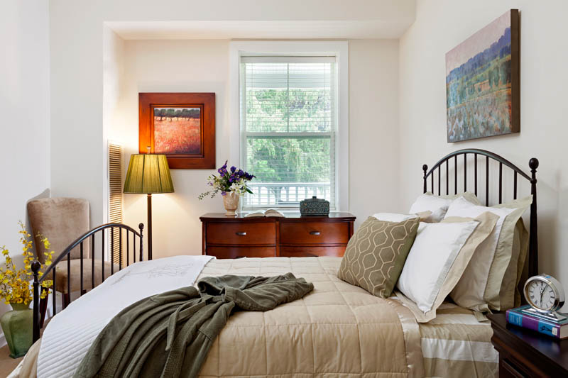 Furnished bedroom with bed, window, and side tables.