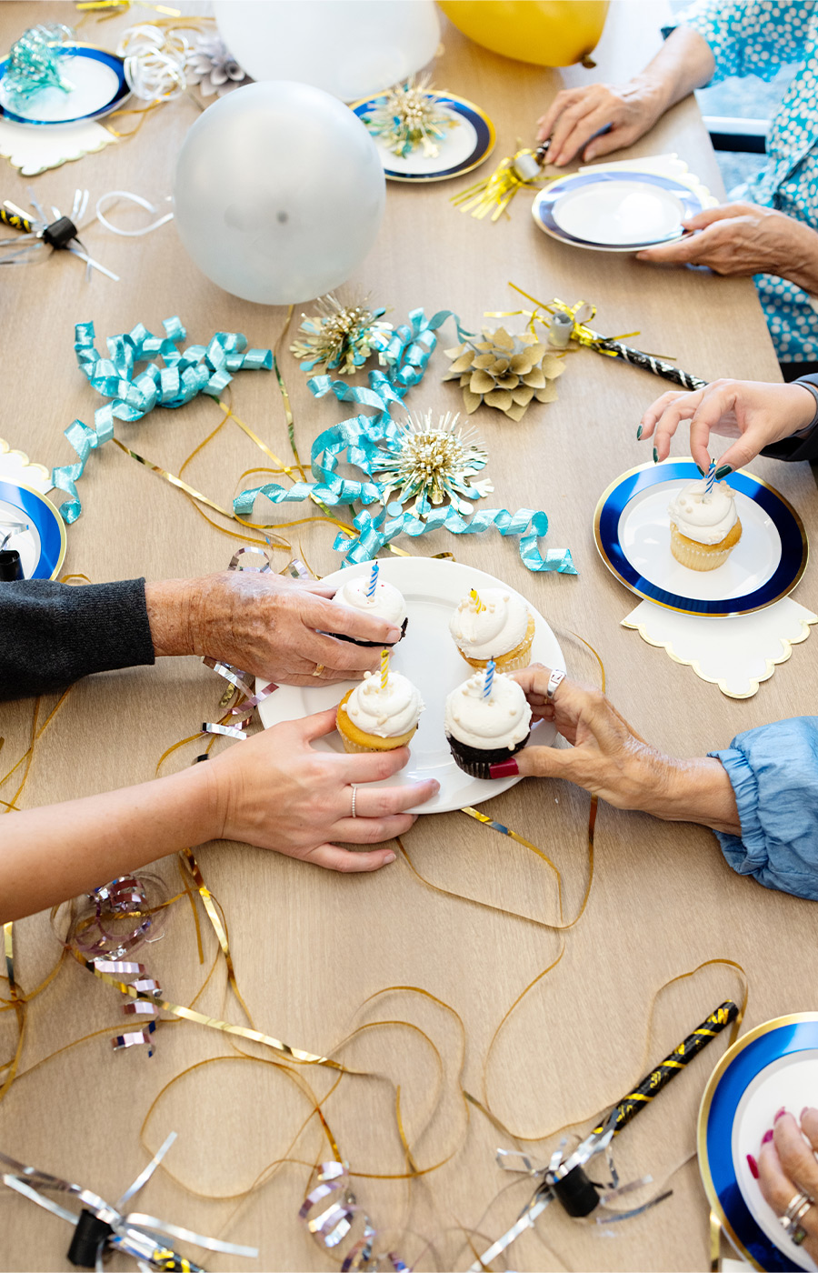 A bunch of people grabbing cupcakes.