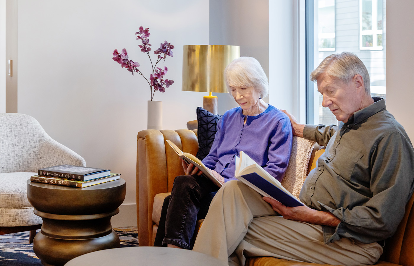 Two people reading on the couch.