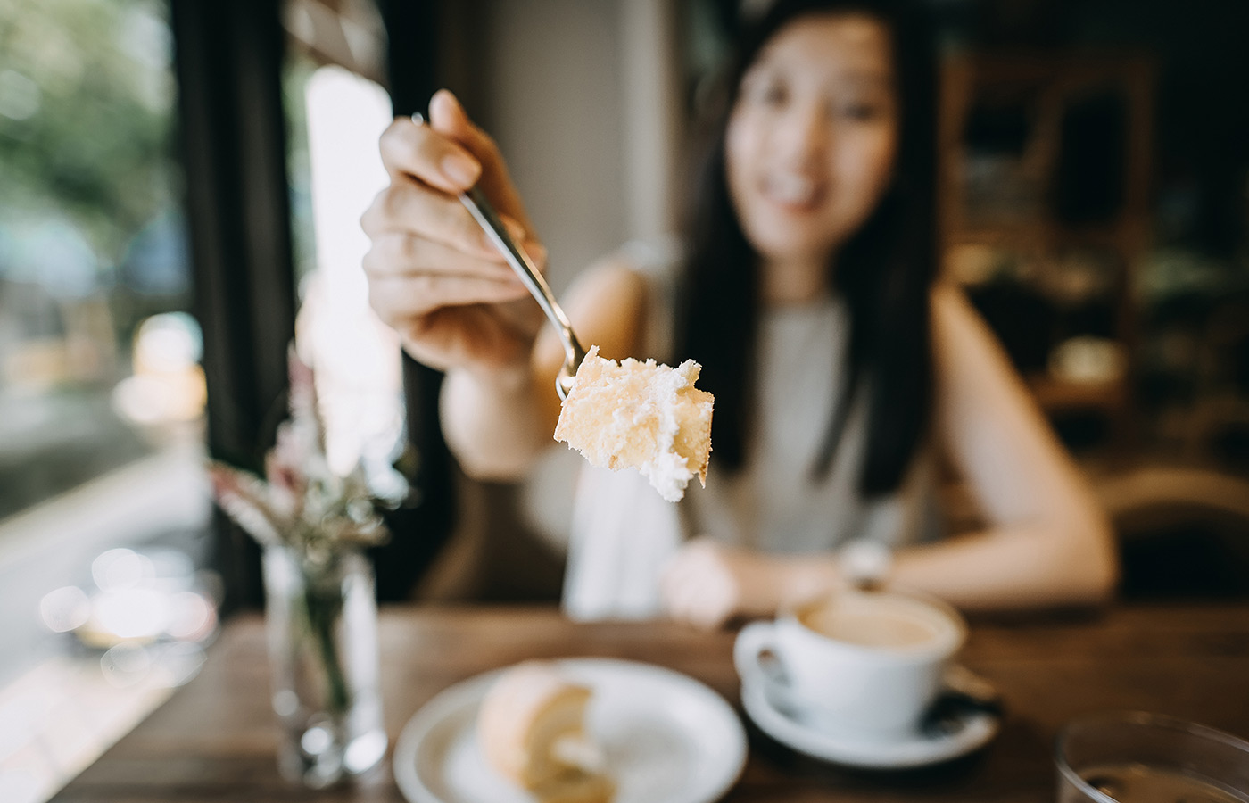 A person holding out a fork with food on it.