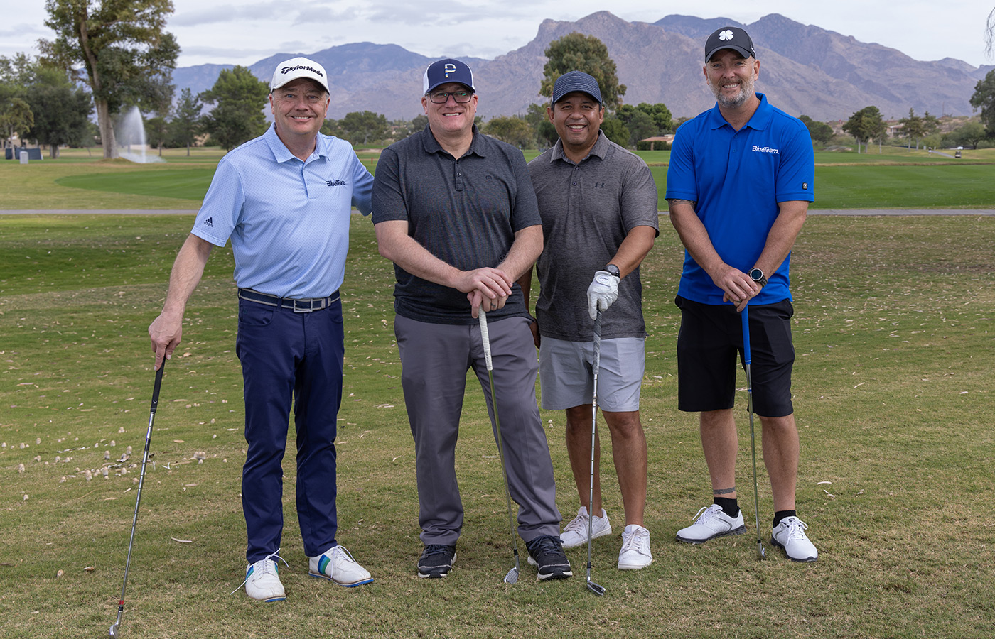 A group of people standing next to each other on the golf course.