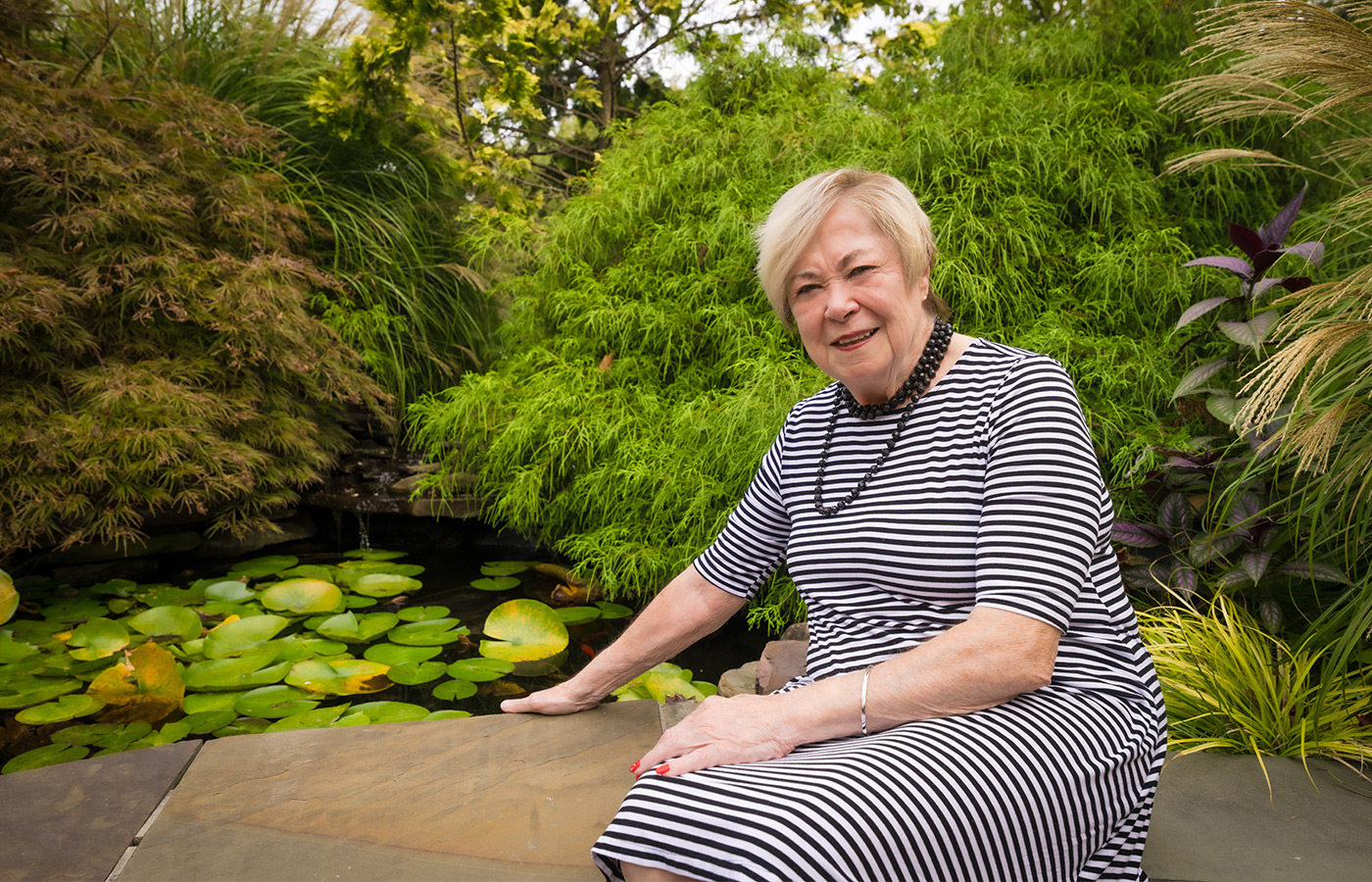 A resident is smiling outside among nature