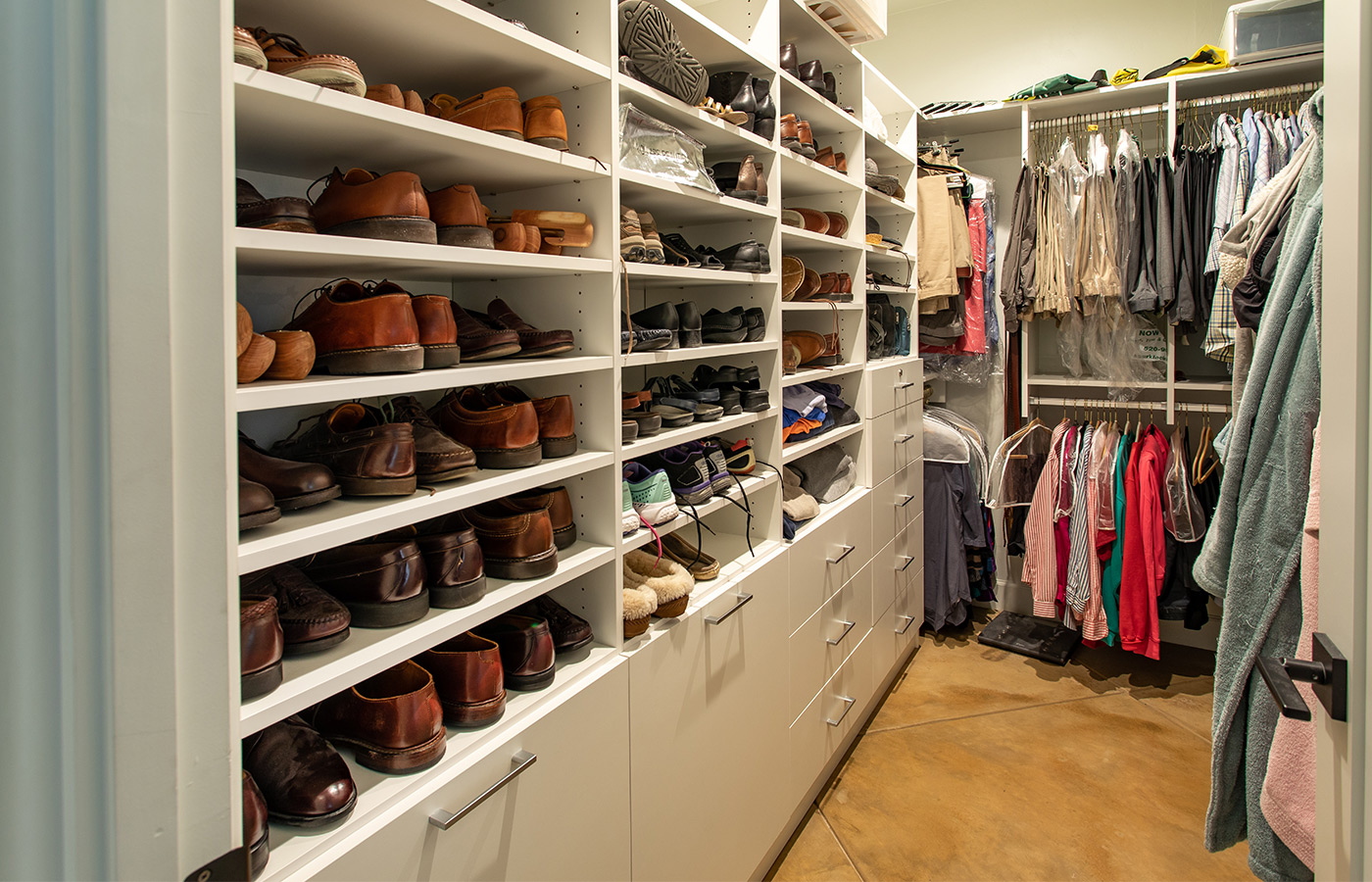 Closet filled with clothes and footwear.