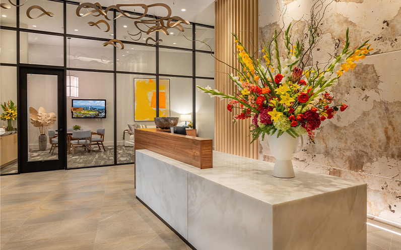 A front desk with a large floral arrangement on it.