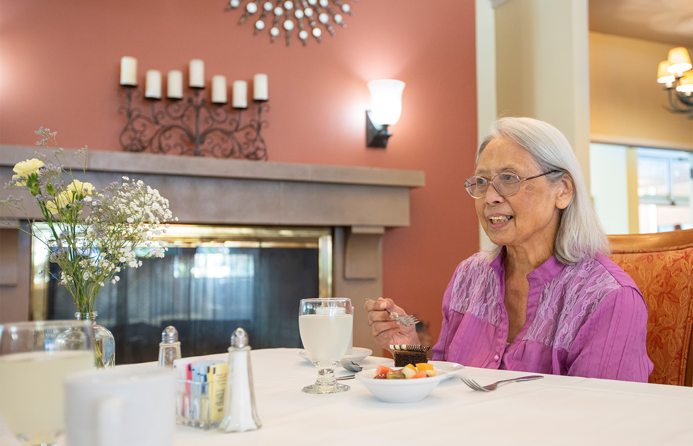 A person eating dessert in a dining room.