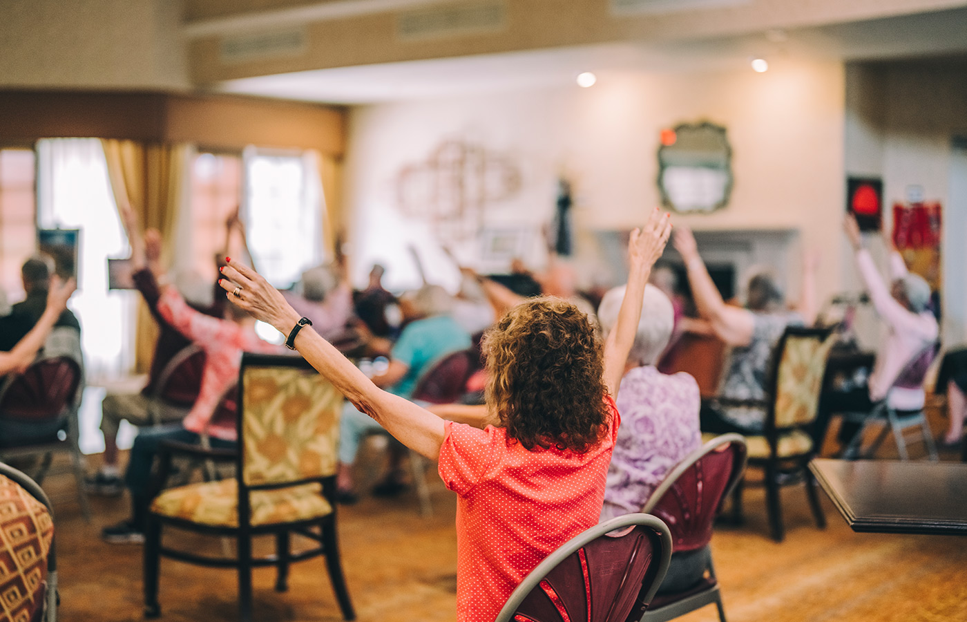 Crowd of people raising their hands in a class.