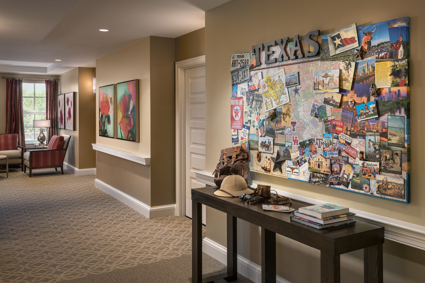 Hallway with table along wall and large piece of art hanging