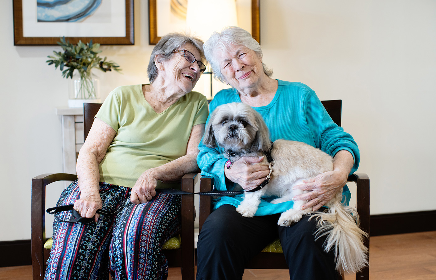 People sitting on a couch with their dog.