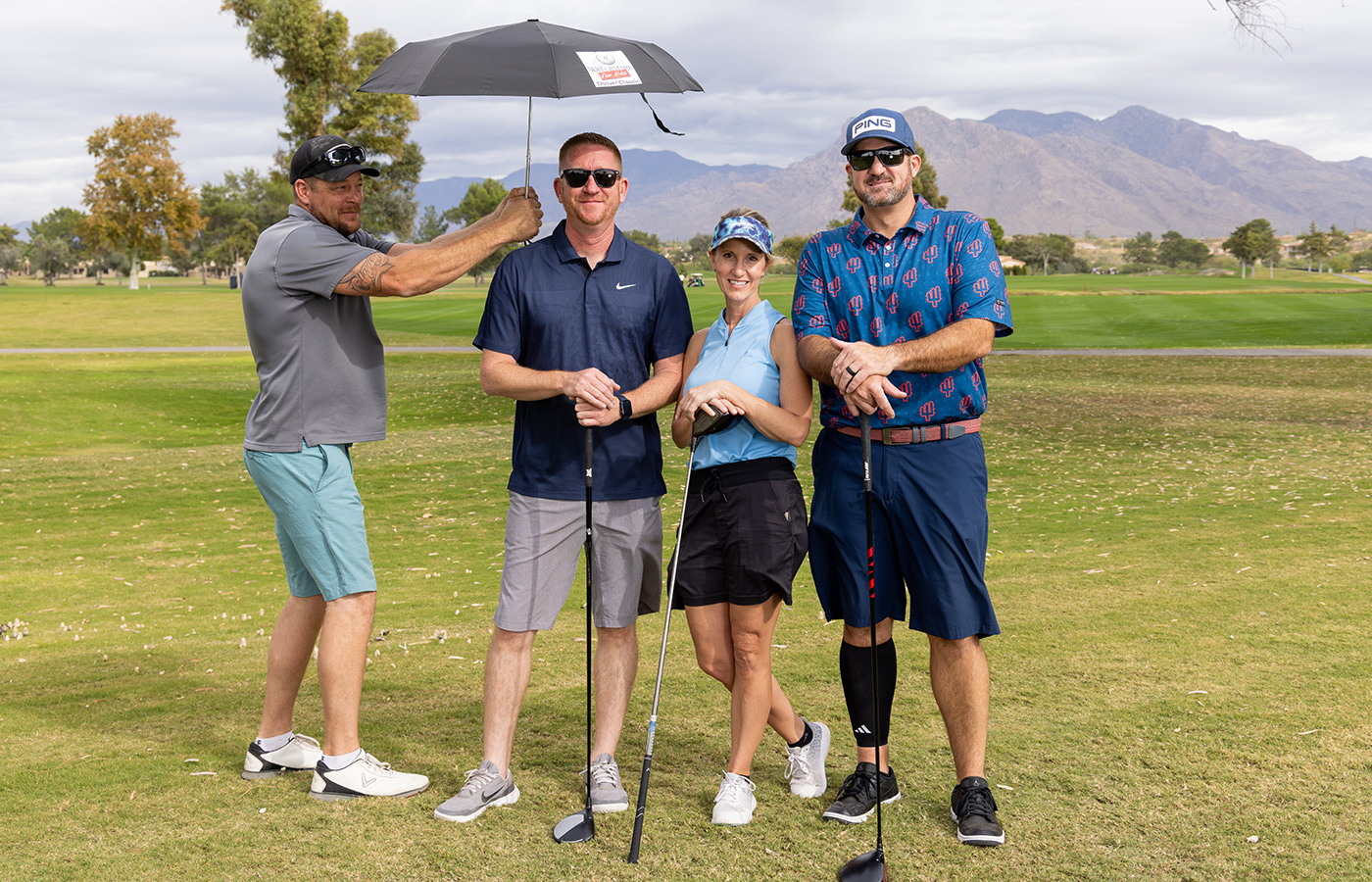 A group of people standing next to each other on the golf course.